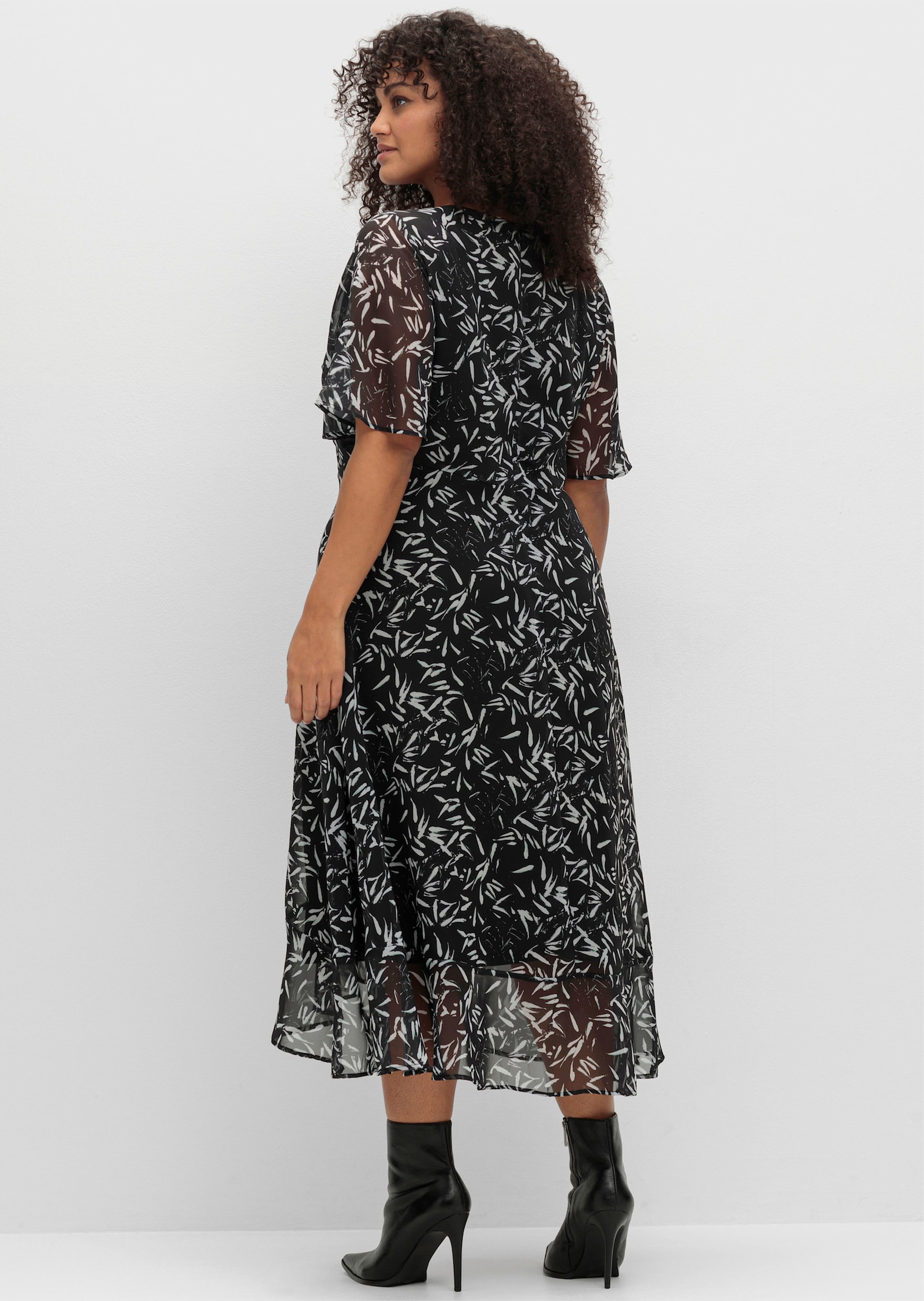 sheego Chiffonkleid mit Blumendruck und Volant am Saum - schwarz-weiss gemustert