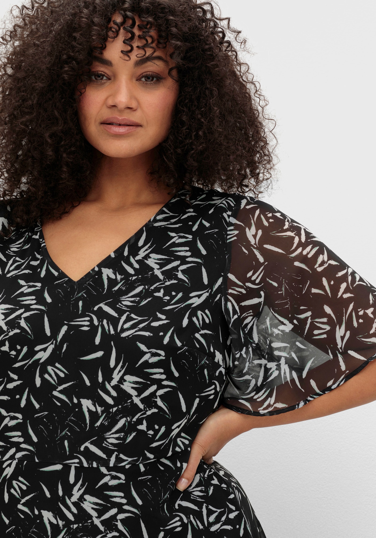 sheego Chiffonkleid mit Blumendruck und Volant am Saum - schwarz-weiss gemustert