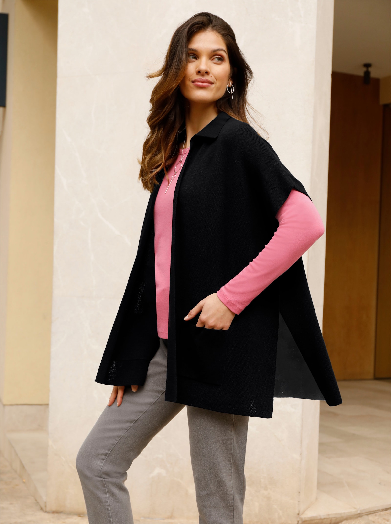 Stickad poncho med påsydda fickor - svart