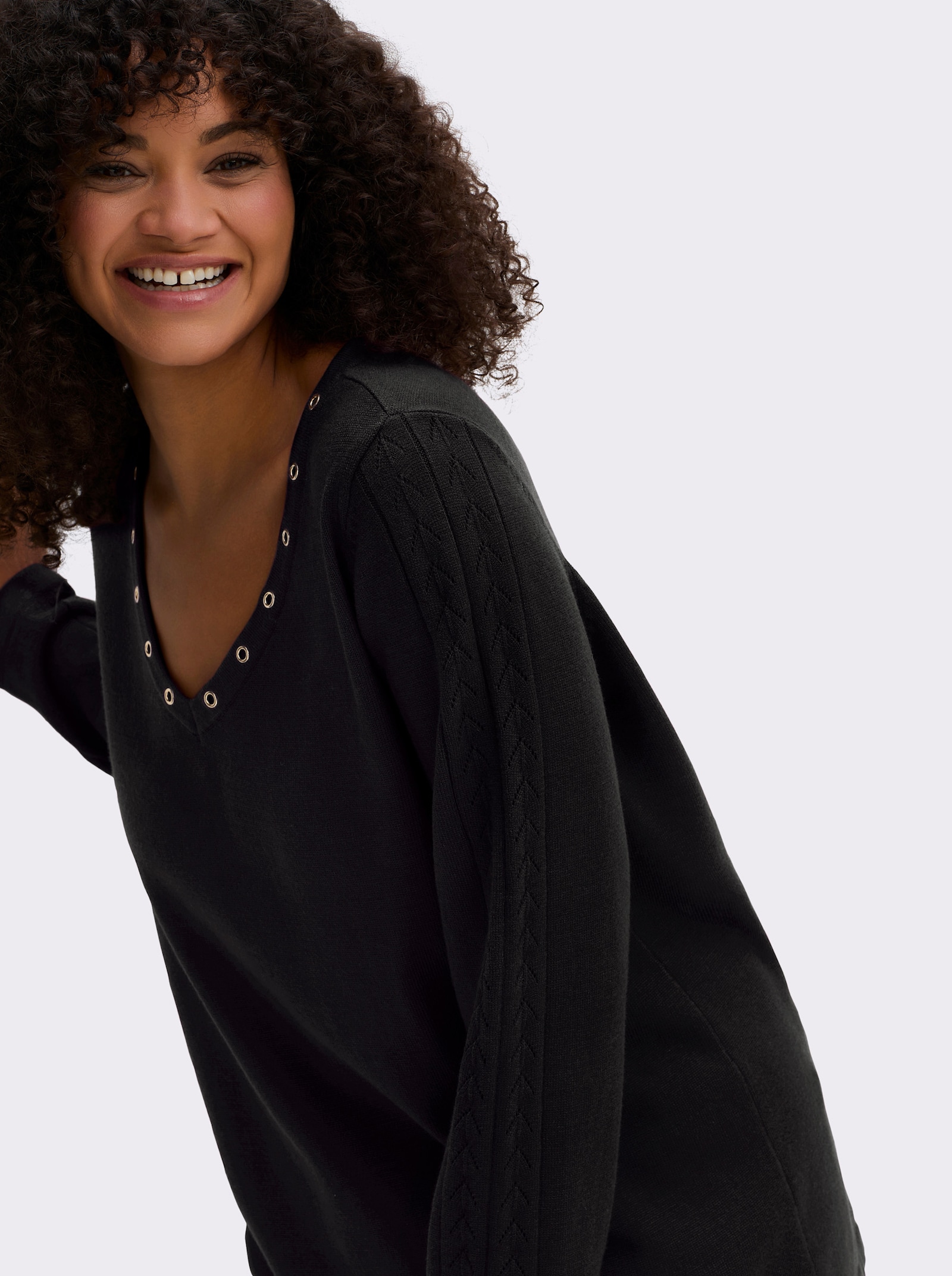 sheego Pullover mit tiefem V-Ausschnitt und Ösenverzierung - schwarz