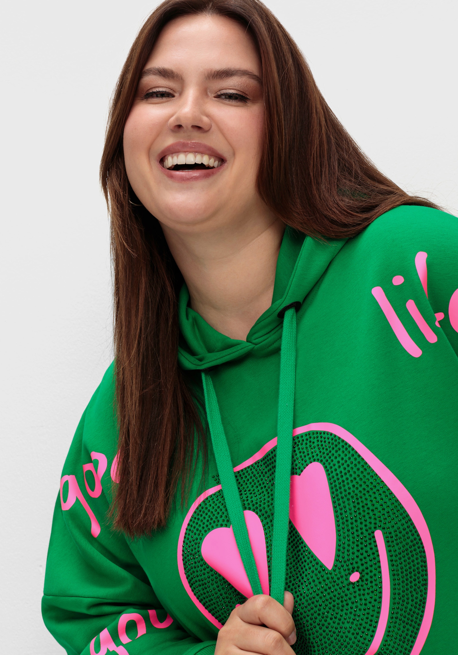 sheego loves miss goodlife Kapuzensweatshirt mit Smiley-Druck und Glitzersteinen - dunkelgrün-bedruckt
