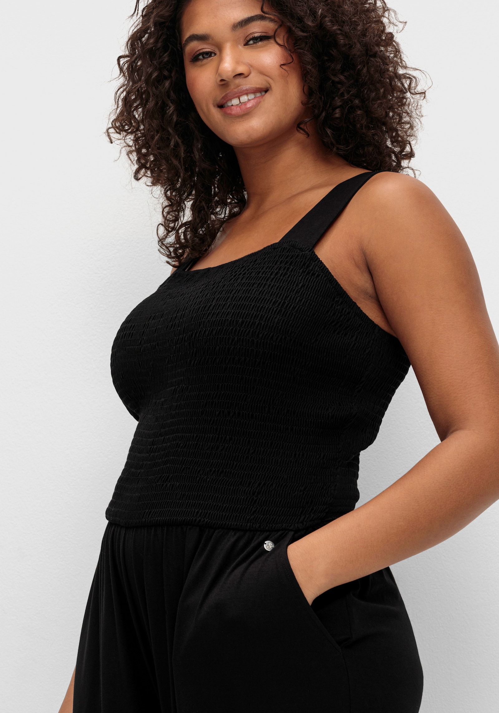 sheego Jumpsuit mit Smok-Oberteil und weitem Bein - schwarz